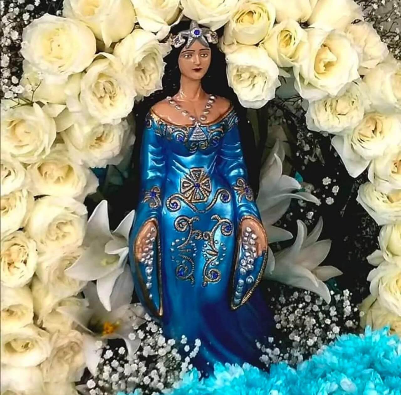 Imagem sagrada cercada de rosas brancas em ritual de luz