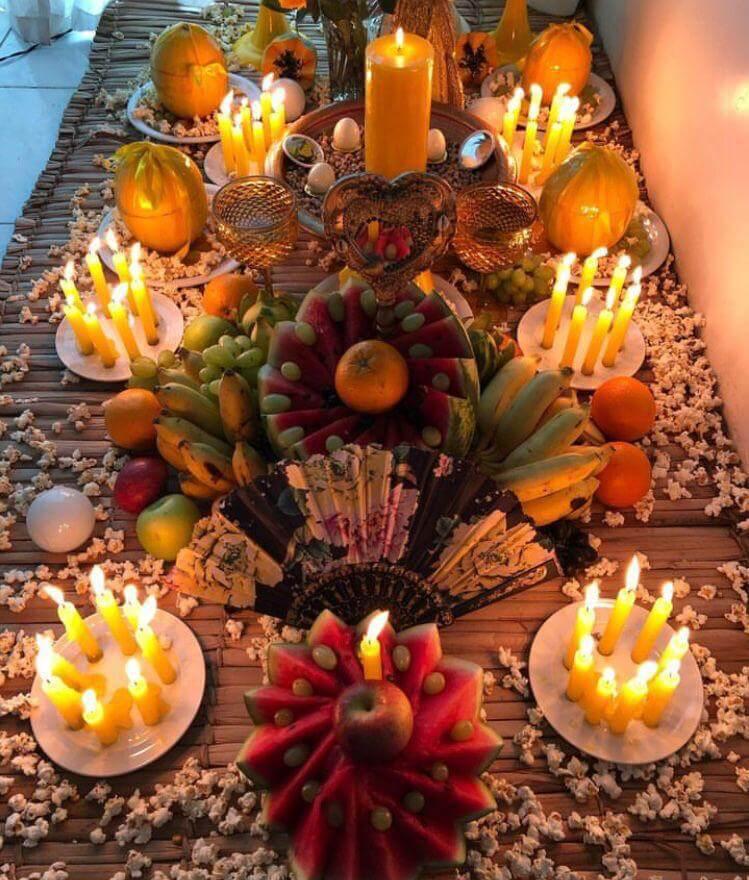 Mesa de oferenda com frutas, velas e elementos naturais